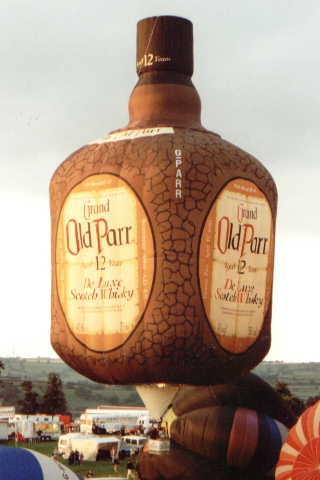 Brown square bottle with black squiggles to represent dimpled glass. Each side has a large oval 'sticker' giving the product details, and logo.