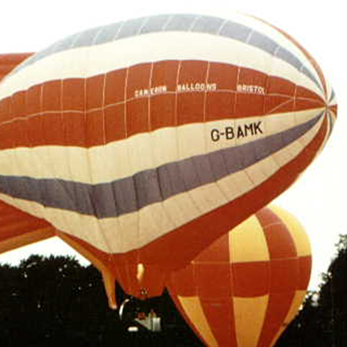 Horizontal striped airship, each quarter being red, white, blue, white, red. The two fins are red.