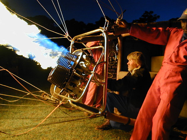 Colour picture of Robin Batchelor inflating a balloon in the dark with African crew assisting