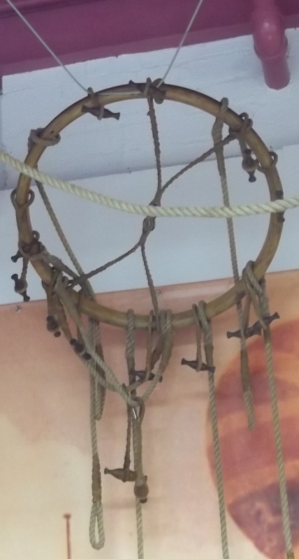 Wooden ring with approximately 12 ropes with wooden toggles to connect the basket to the gas envelope