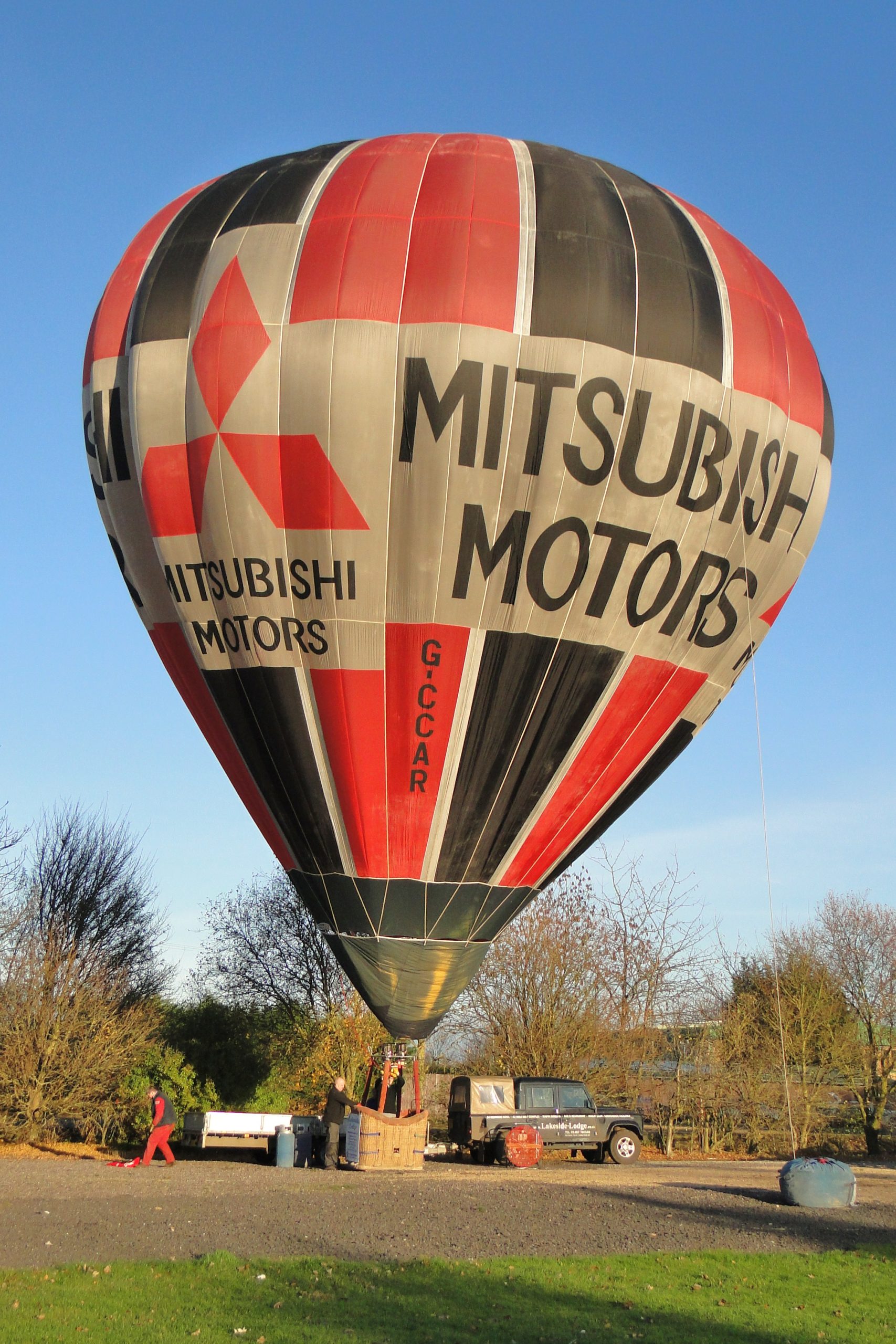 Wide black and red vertical stripes with white edge. White equator featuring company name and logo.
