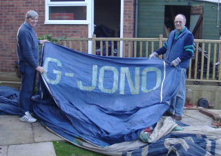 Two people holding the registration panel of the balloon.