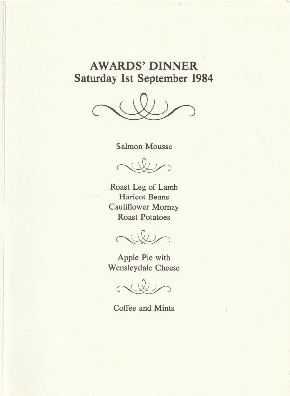 Lists the menu which includes salmon mousse, roast leg of lamb, apple pie with Wensleydale cheese, coffee and mints.