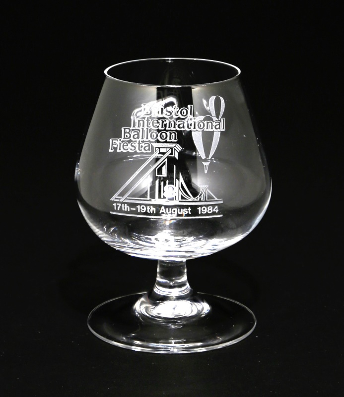 Brandy glass with engraved image of Clifton Suspension Bridge with two hot air balloons flying over, event name and date given. 