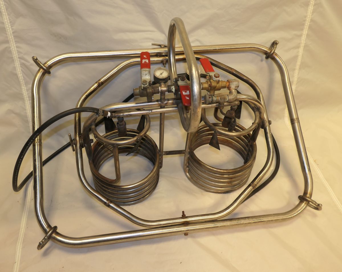 Pilots view under the burner showing the 2 gas pressure valves, the two burners and pilot lights, and the burner on/off control lever.