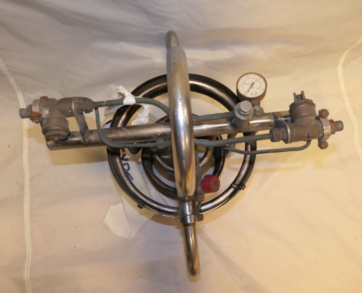 Pilot's view from underneath the burner including the burner handle and the gas pressure gauge.