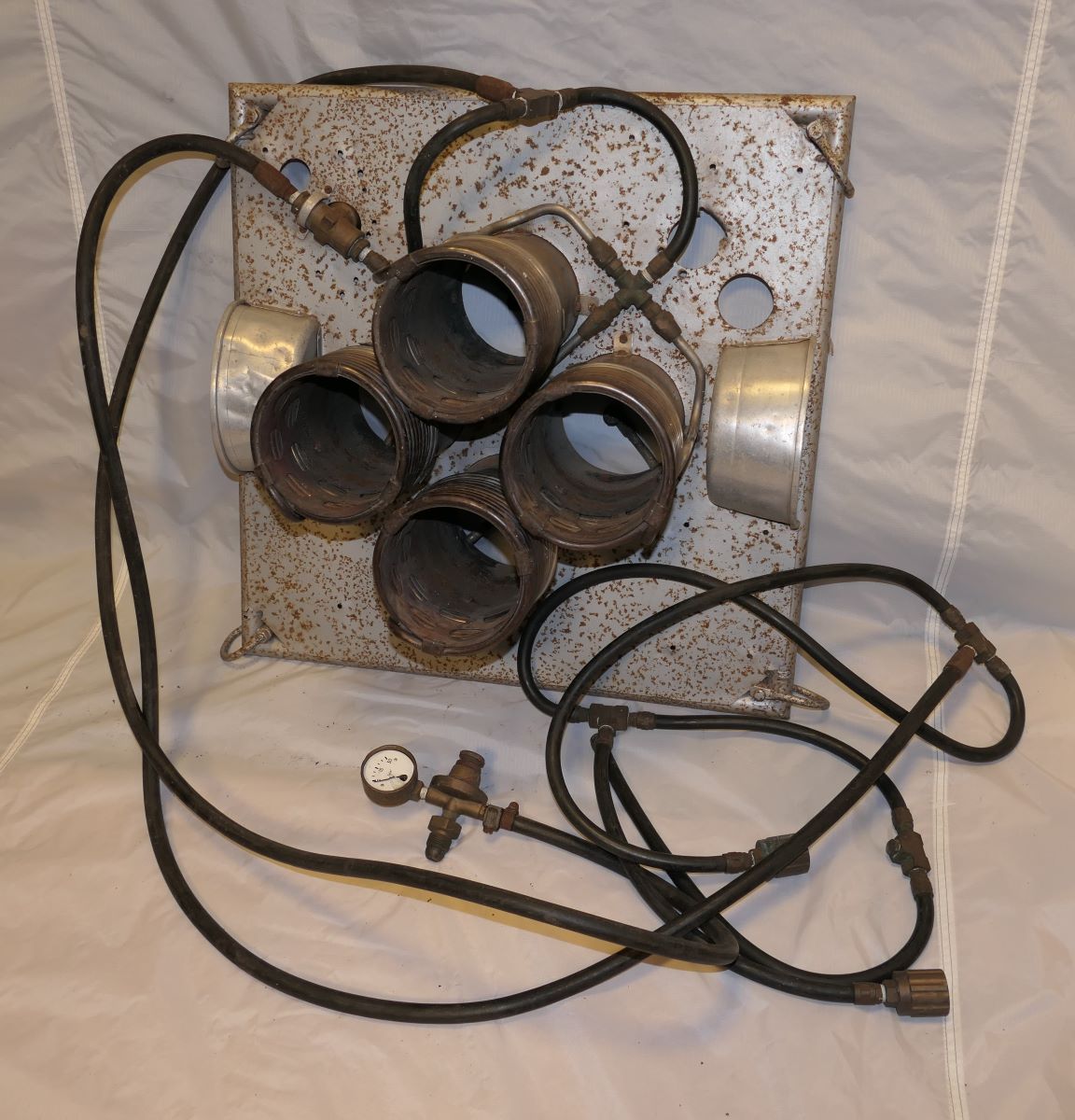 Four coil burners set in a frame consisting of a metal sheet with holes cut out for the burners and shackles in each corner for the flying wires. 2 hoses with additional connector points feed the gas to the burners.