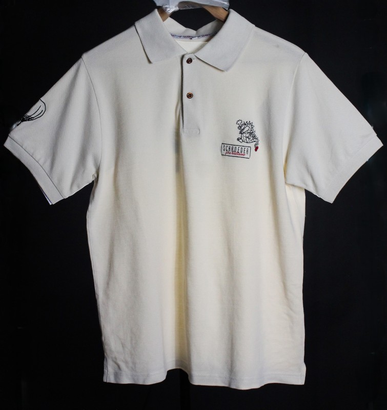 Off white polo shirt with company name and dragon logo on left chest in black with tip of tail and 'fire balloons' in red