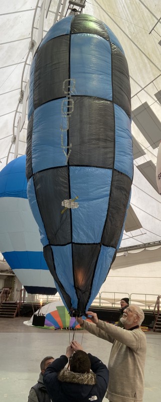 Narrow model balloon with very small mouth, blue and navy blue chequered pattern.