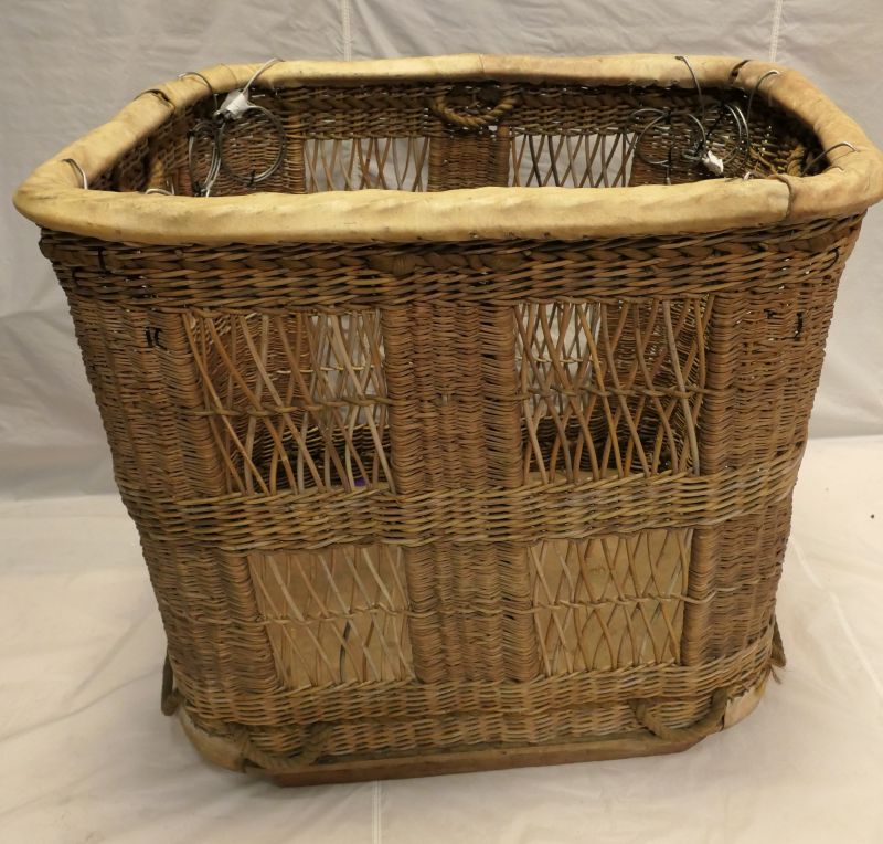 Wicker basket with 8 flying wires to connect to the balloon. Long sides have 4 rectangles of open wicker work comprising wicker diagonal crosses.   