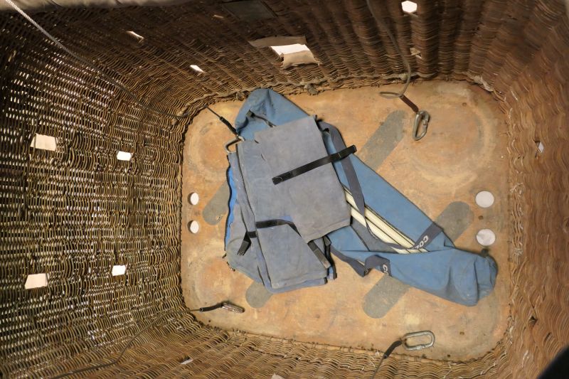 View looking into the bottom of the basket where the blue pole bag, poles and pole covers are stored.    