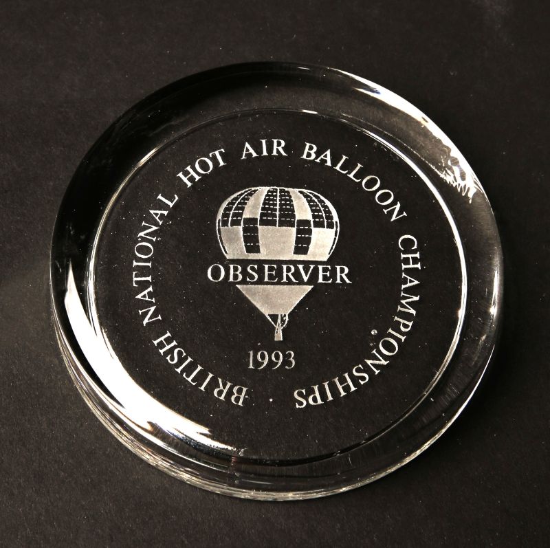 Clear glass circular paperweight with event name encircling a check balloon with 'Observer' across it and the year below. 