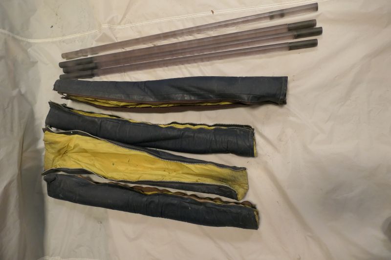 4 clear plastic burner support poles and black pole covers lined in yellow fabric. 