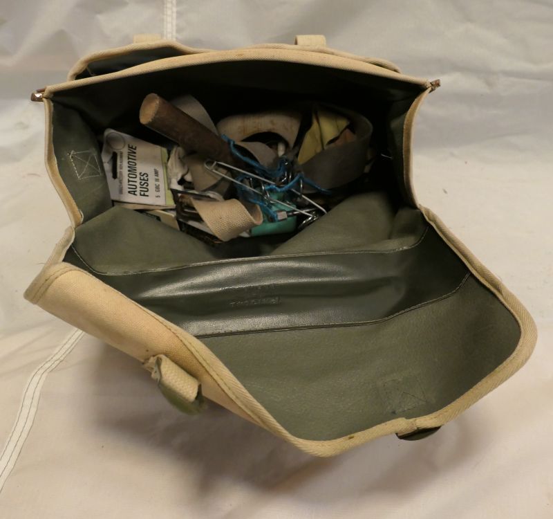 Cream fabric flight bag with a green lining, containing pins for the poles, plus straps, ignition and gloves.